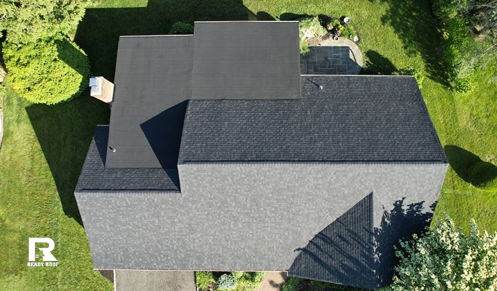 A top-down aerial view of a newly finished home section showing completed flat roof repair.
