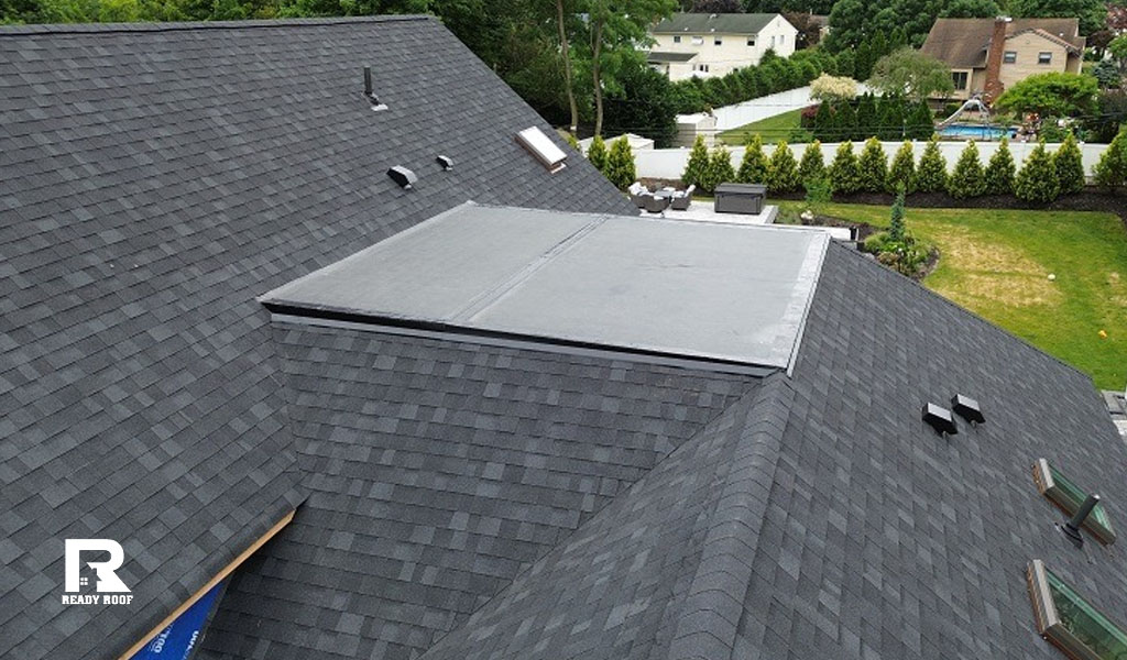 A top-down aerial view of a newly finished home section showing completed flat roof repair.
