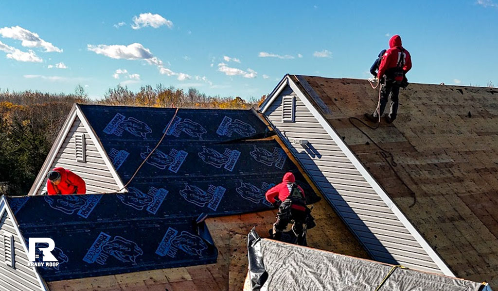 Ready Roof workers installing dark underlayment on a steep roof, representing your roof repair cost on Long Island.