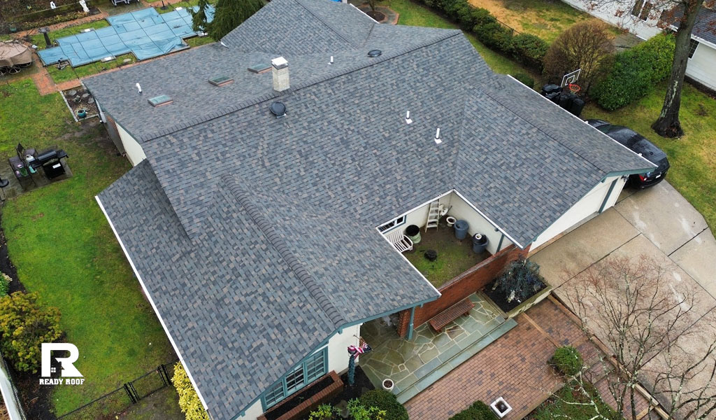Aerial view of a newly installed roof on a sprawling home, highlighting the metal roofing vs asphalt shingles comparison perfectly.