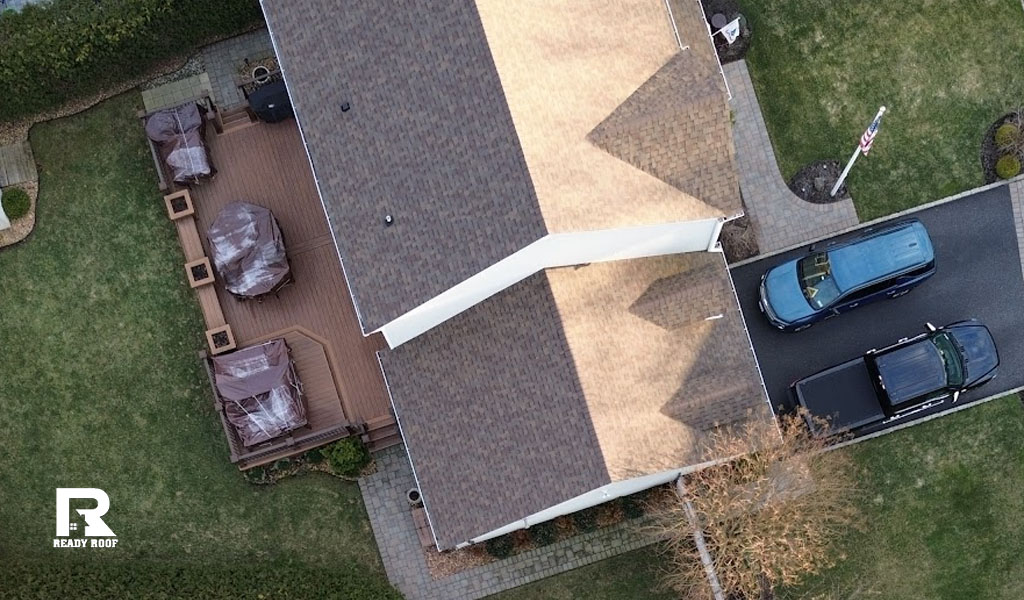 Top down view of a residential property and deck, illustrating the visual outcome of a roof repair vs replacement decision.