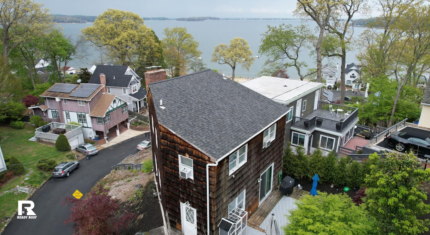 Coastal homes viewed from above, featuring a tall house next to a white TPO vs EPDM flat roof building nearby.
